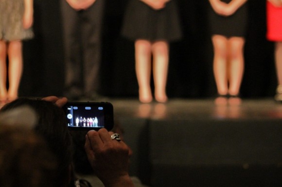 A audience member takes a photo on their cell phone of students who were recognized. Credit: Tom Sofield/LevittownNow.com