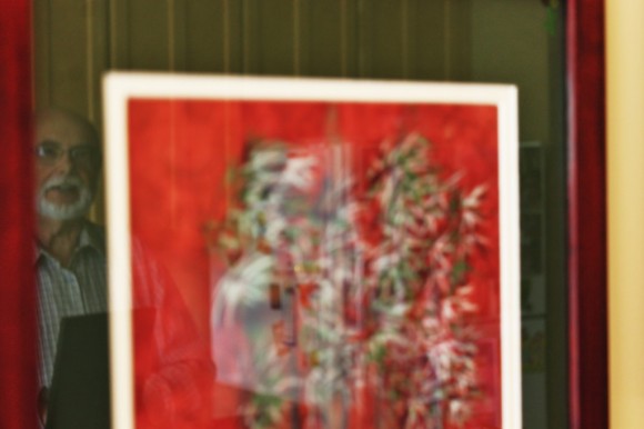 Champine's reflection in glass frame of a painting he did. Credit: Tom Sofield/LevittownNow.com