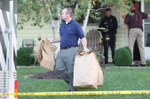 A detective brings evidence out of the house where the baby was found. Credit: Tom Sofield/LevittownNow.com