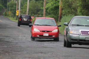 Cars driving through the craters on Big Oak Road. Credit: Tom Sofield/LevittownNow.com