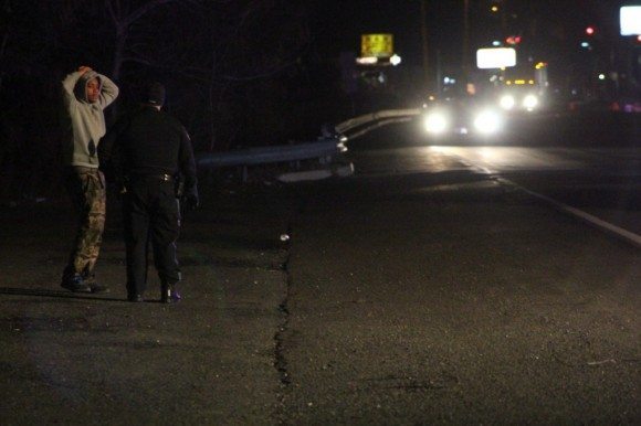 A police officer talks to a man near the scene.  Credit: Tom Sofield/LevittownNow.com