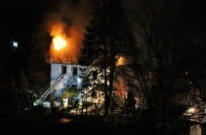 Fire shoots through the roof of the home Tuesday night. Credit: Tom Sofield/LevittownNow.com