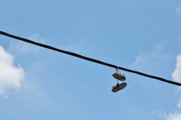 A pair of sneakers hang from a utility line above Woodland Avenue in Penndel on a recent afternoon. Did you know: The origin and meaning of throwing sneakers over a utility wire is unknown. There are many explanations ranging from kids having a good time to the shoes being an indicator of a drug house or memorial for a fallen friend.  Credit: Tom Sofield/LevittownNow.com
