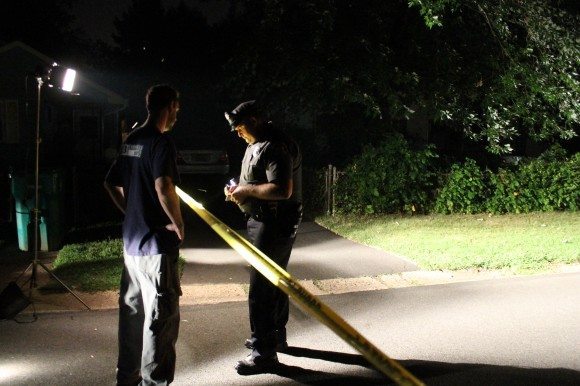 A police officer talks to a journalist who said he was assaulted at the crime scene.  Credit: Tom Sofield/LevittownNow.com
