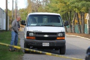 An investigator looks inside a white van police say is connected to the murder. Credit: Tom Sofield/LevittownNow.com