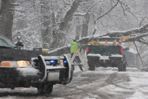 A police car blocks Poplar Street in Middletown as a public works crew member puts up a barricade. A tree fell and knocked down several live electrical wires late in the afternoon. Credit: Tom Sofield/LevittownNow.com