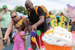 Ann and Corey Hobbs check out the Sesame Place birthday cake with their daughter, Mya.  Credit: Tom Sofield/LevittownNow.com