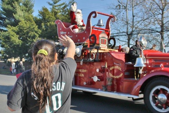 Santa waves to a girl along MIll Creek Road outside of the Orangewood Apartments. Credit: Tom Sofield/LevittownNow.com