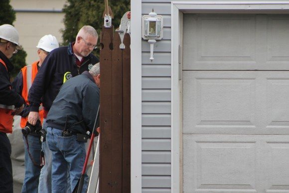 Authorities using a forceable entry tool on the garage Friday afternoon. Credit: Tom Sofield/LevittownNow.com
