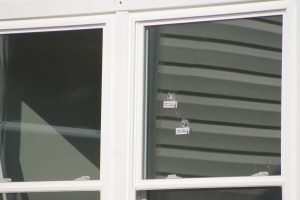 Two bullet holes in the window of a Cleveland Street home. Credit: Tom Sofield/LevittownNow.com