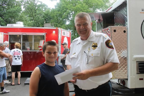 Michael Sailman, 9, makes a donation to Langhorne Borough Chief of Police Steven Mawhinney. Credit: Tom Sofield/LevittownNow.com