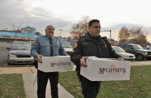 adfadfa Cpl. Steven Langan (right) and Officer Bruce Rhodunda carry Thanksgiving dinner to the Bodine family.  Credit: Tom Sofield/LevittownNow.com
